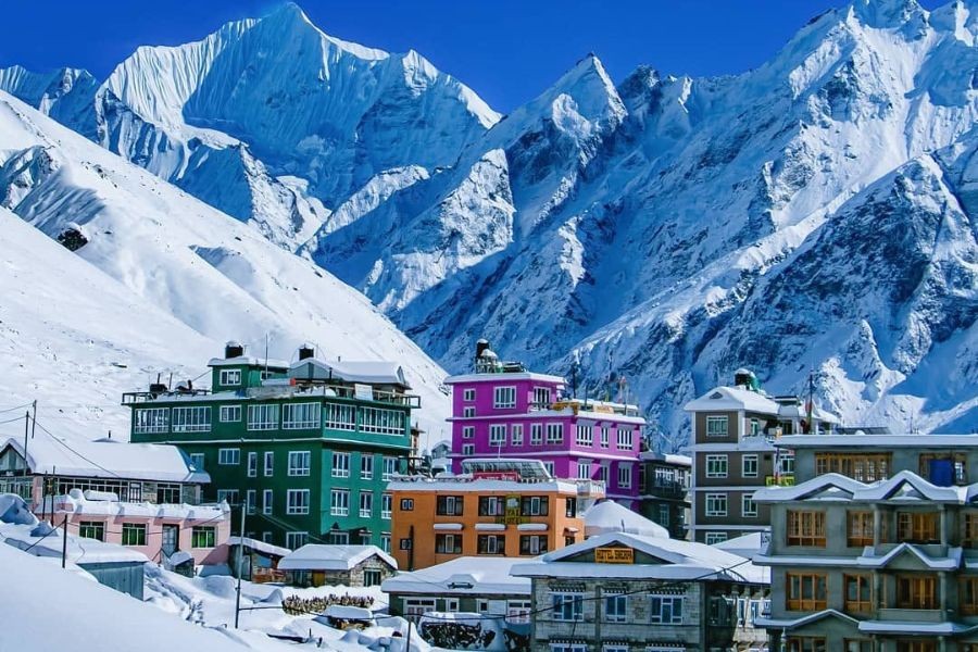 Colorful mountain lodges and teahouses nestled in snowy Himalayan valley